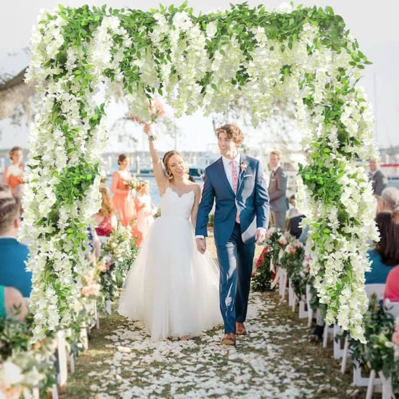 White wisteria wedding arch with cascading blooms and greenery at an outdoor ceremony in Los Angeles