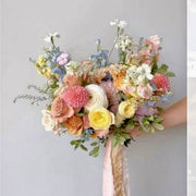 Wildflower-style bridal bouquet with dahlias, ranunculus, roses, and delphinium with trailing ribbons in Los Angeles