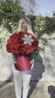 Festive floral gift with vibrant red roses and natural holiday accents, beautifully styled for Chris