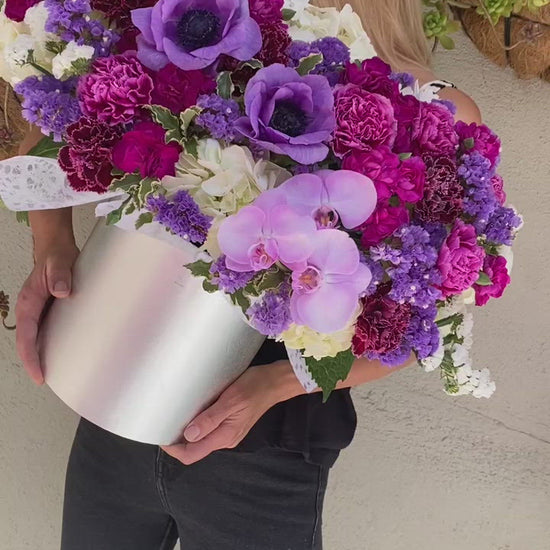 Luxurious floral arrangement with purple blooms and lush greenery, ideal for romantic occasions and upscale celebrations