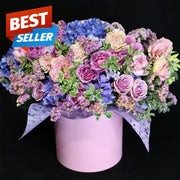A handmade floral gift featuring fresh pink and blue flowers, presented in a vibrant yet vibrant design for luxurious delivery.
