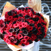 Luxurious mix of deep red and black roses in a grand arrangement, ideal for romantic gestures and premium delivery