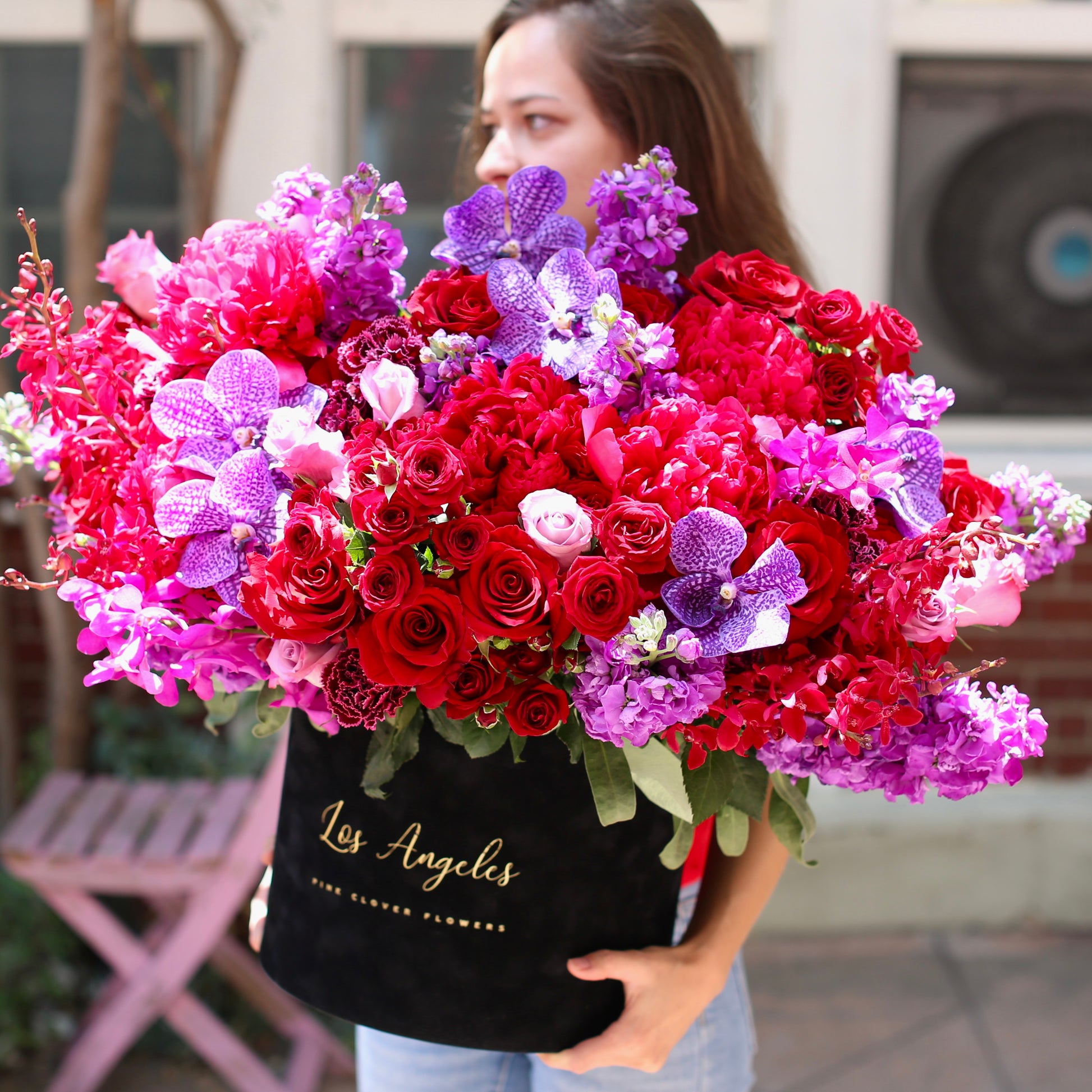 Elegant red roses and orchids floral design, beautifully styled in a large decorative box for luxury gifting and special celebrations