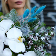 Beautifully styled Christmas bouquet with pine, orchids and soft accents, ideal for premium gifting 