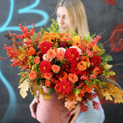Vibrant fall floral design with warm-toned blooms and rustic accents, styled for premium seasonal gifting
