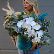 Festive floral design with blue and white tones, showcasing fresh pine and orchids for a luxurious h