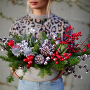 Vibrant Christmas bouquet with red berries, pinecones and frosted foliage, styled for festive holida