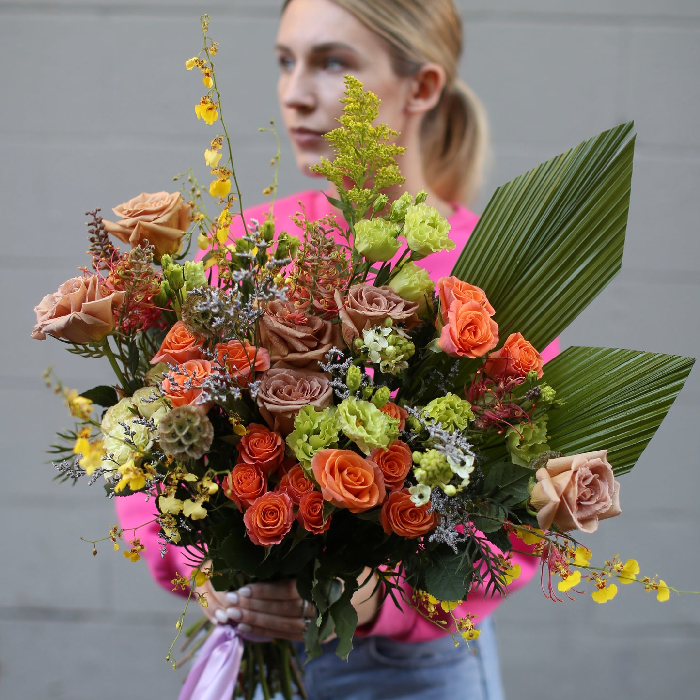 Cheerful bouquet showcasing radiant yellow tones with soft pink accents, arranged in a lively and elegant style