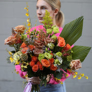 Cheerful bouquet showcasing radiant yellow tones with soft pink accents, arranged in a lively and elegant style