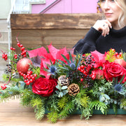 Festive Christmas centerpiece showcasing fresh white flowers and seasonal greenery in a celebratory,